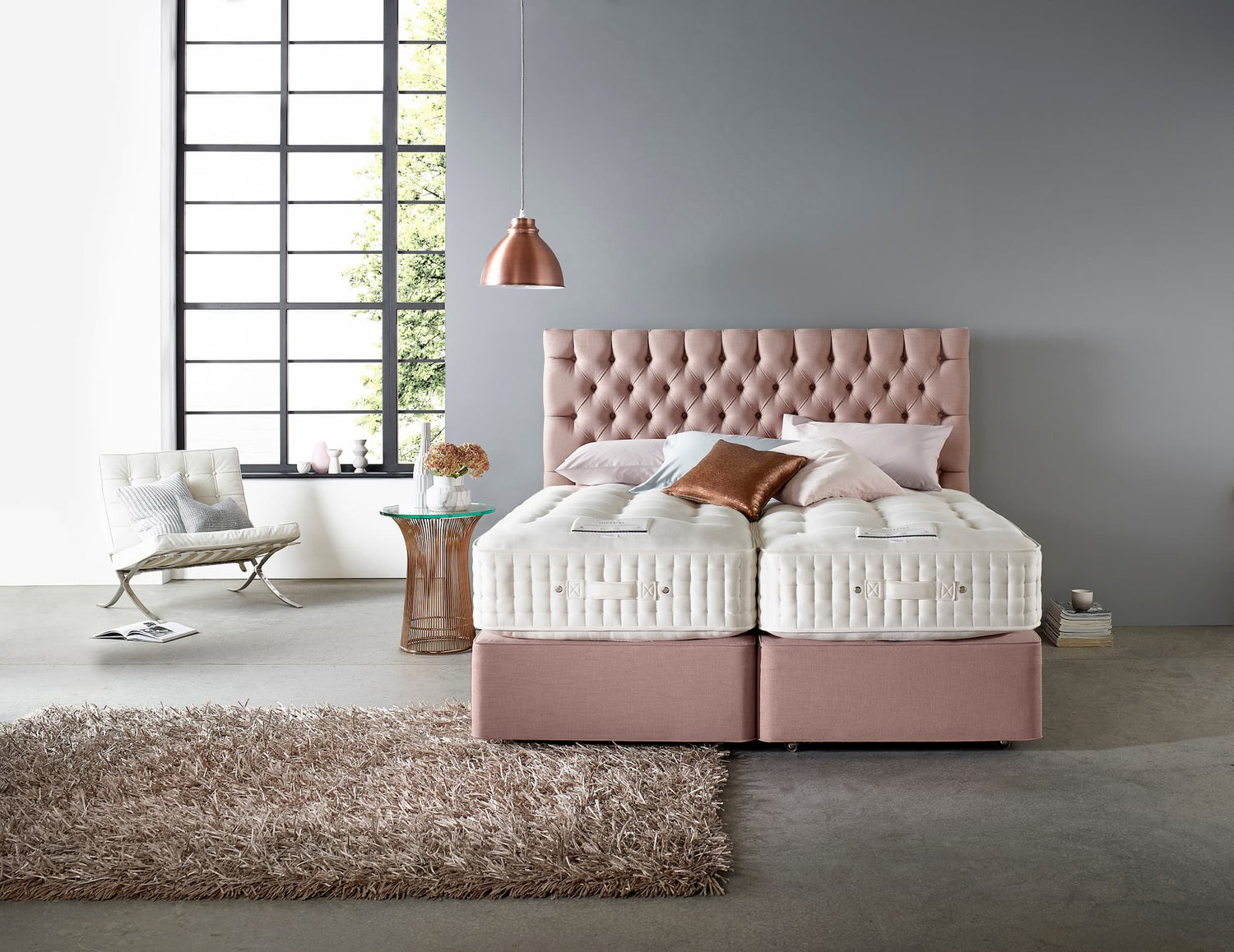 Lit avec matelas séparables Somnus dans une chambre moderne, décorée avec des coussins, un fauteuil et un tapis moelleux
