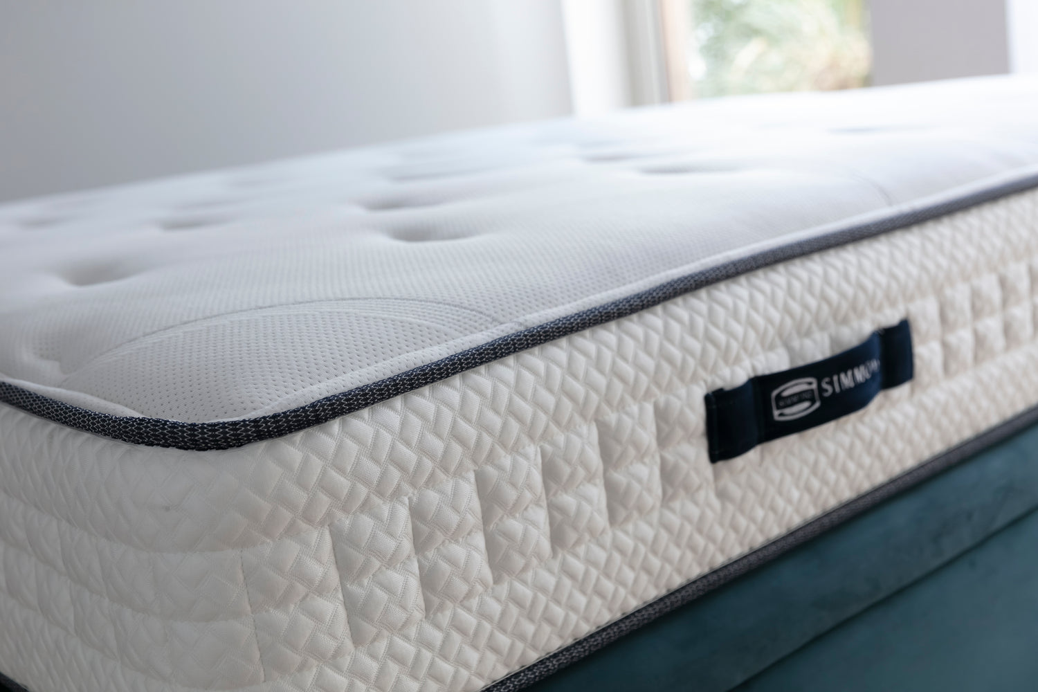 Matelas Simmons avec coutures détaillées, étiquette visible, éclairage naturel