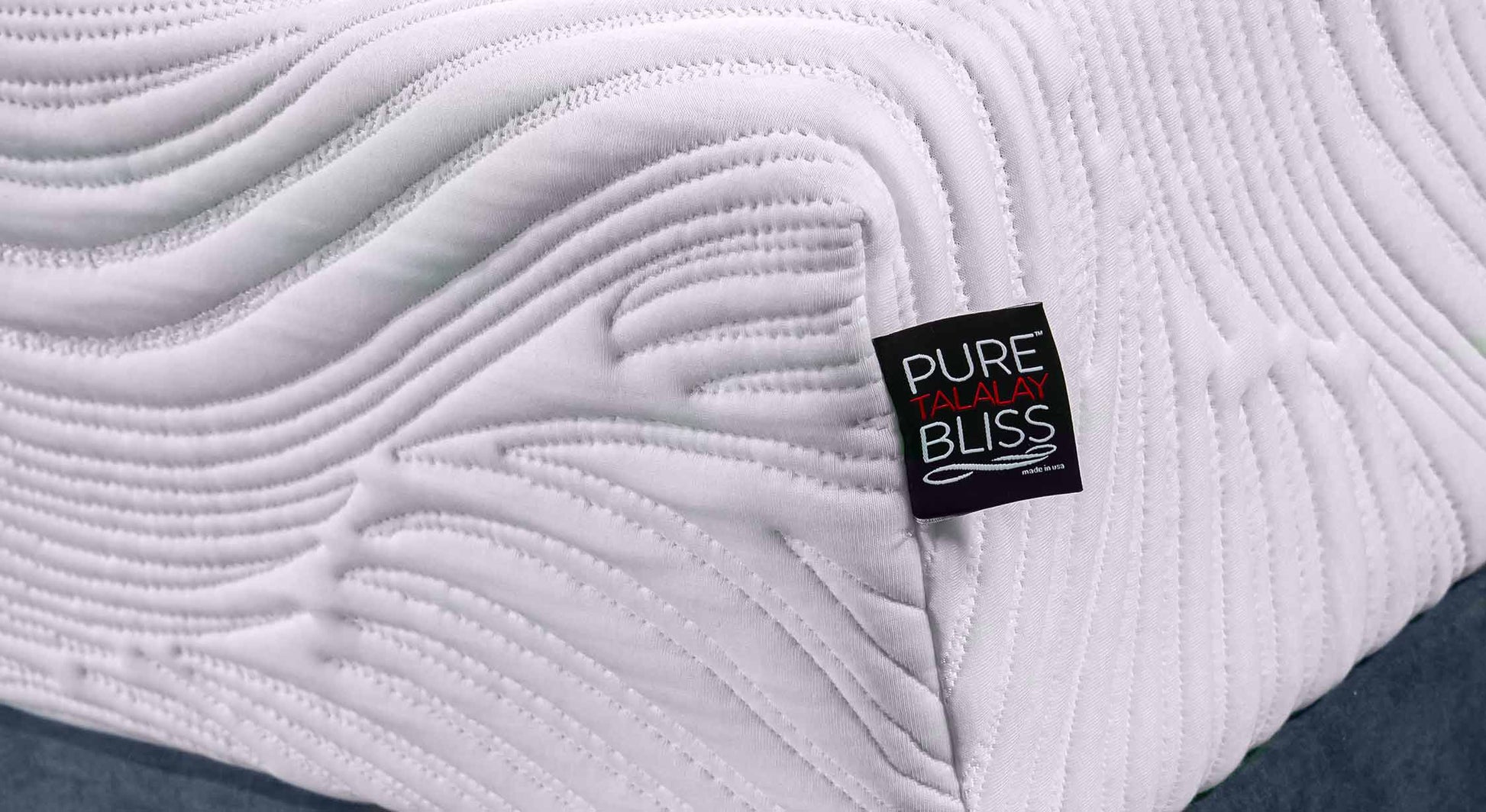 Matelas blanc avec motif ondulé et étiquette "Pure Talalay Bliss"