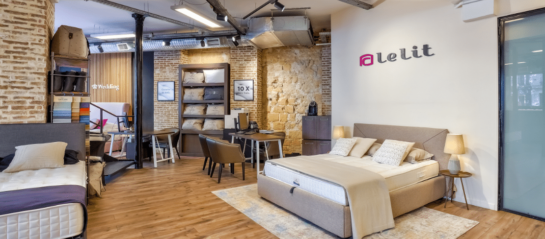 Intérieur moderne du magasin Le Lit Sébastopol avec lits exposés, murs en briques et mobilier contemporain
