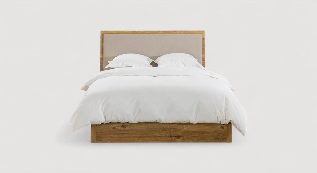 Lit en bois avec tête de lit rembourrée, draps blancs, packshot de la collection Aloe