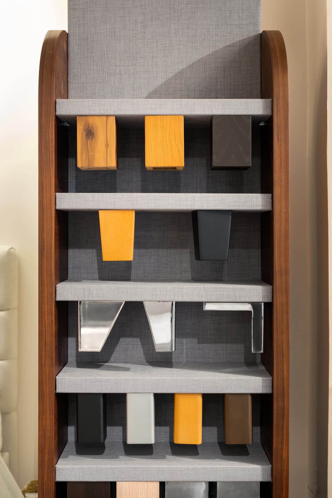 Présentoir en magasin avec divers pieds de lit en bois et métal, exposés sur des étagères grises