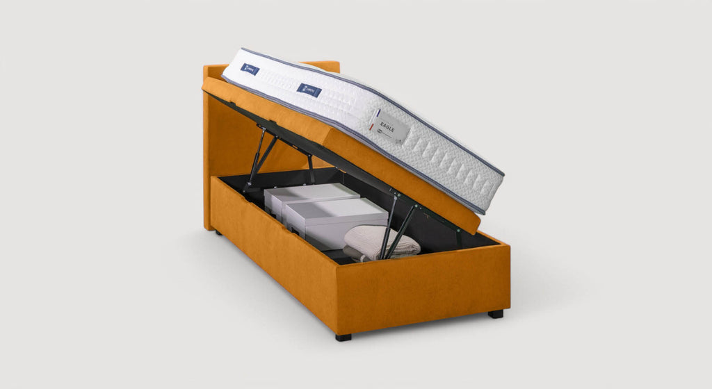 Lit coffre Ouessant en tissu orange avec matelas relevé, montrant un espace de rangement contenant des boîtes et une couverture