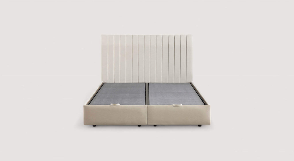 Lit coffre beige avec matelas relevé, montrant un espace de rangement contenant des oreillers et une couverture. Modèle Amsterdam