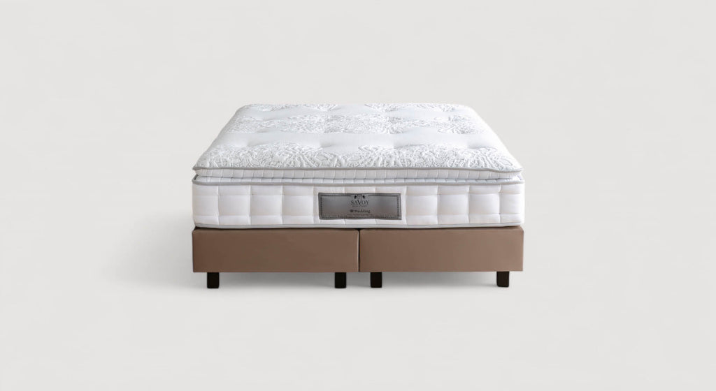 Lit avec sommier à lattes dans une chambre élégante, décorée avec des coussins blancs et jaunes, et des éléments dorés