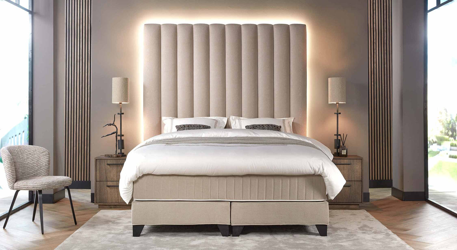Chambre élégante avec tête de lit rembourrée et éclairée, ambiance moderne inspirée de Dubaï, mobilier en bois et tons neutres