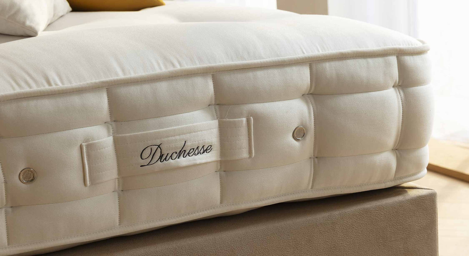 Matelas luxueux Duchesse avec coutures détaillées et étiquette brodée, créant une ambiance élégante et confortable