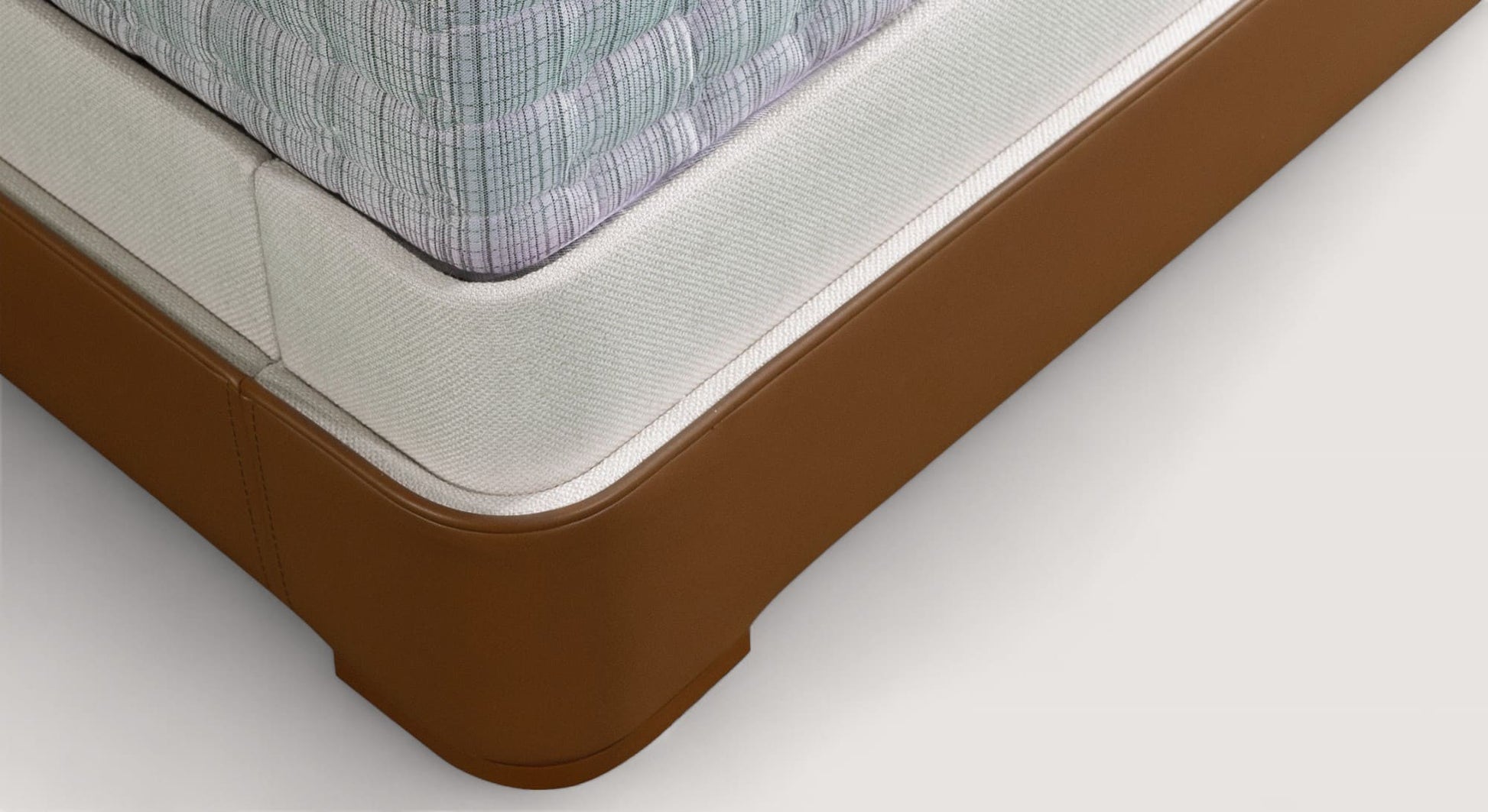 Coin d'un lit coffre Isabel avec base en cuir marron et matelas à motif quadrillé