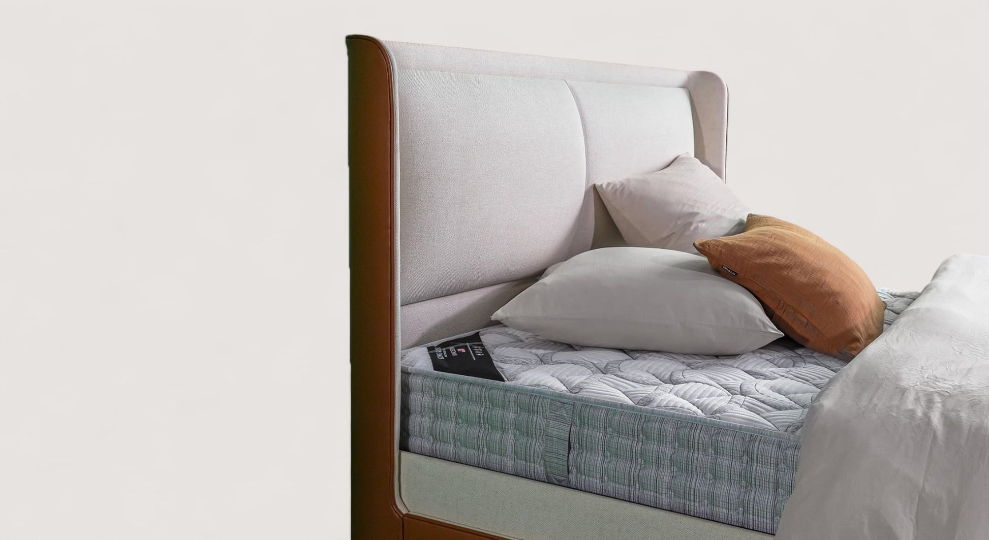 Lit Isabel avec tête de lit rembourrée, matelas texturé et oreillers, vue de côté