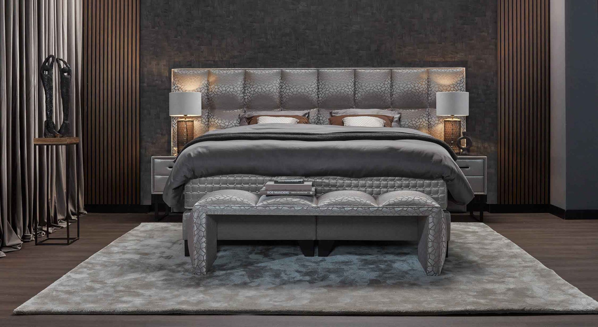 Chambre élégante avec lit Madison, banc assorti au pied, tapis gris et sculptures décoratives, créant une ambiance sophistiquée
