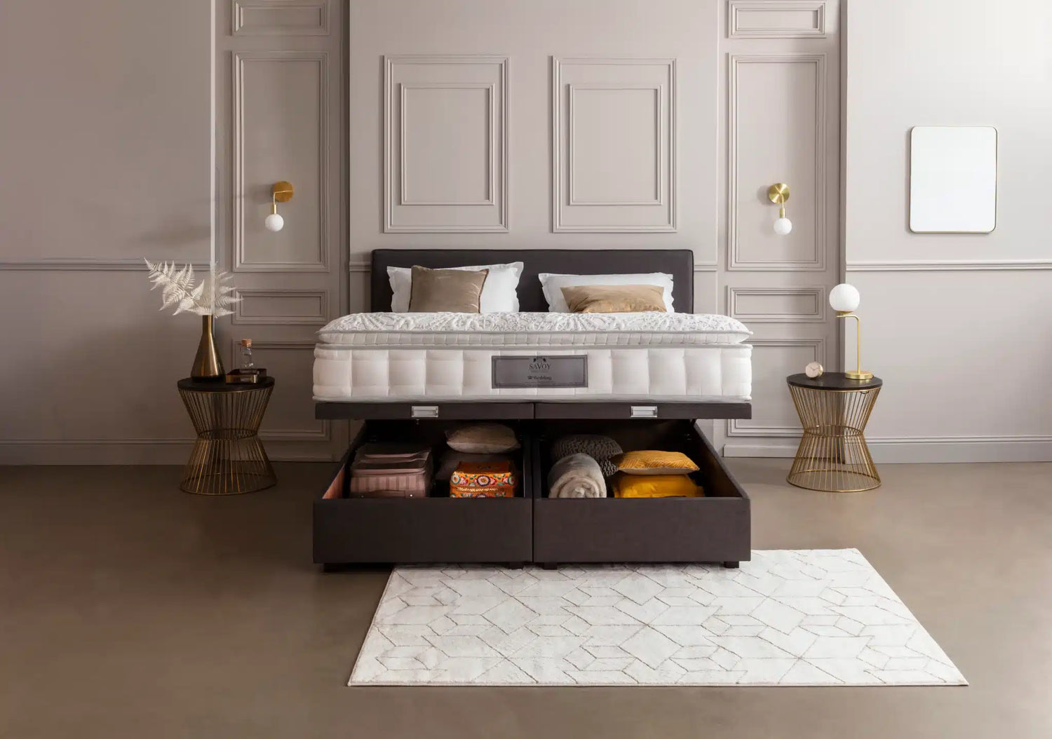 Lit coffre moderne avec rangement ouvert, entouré de tables d'appoint dorées et décoratives, dans une chambre élégante aux tons neutres