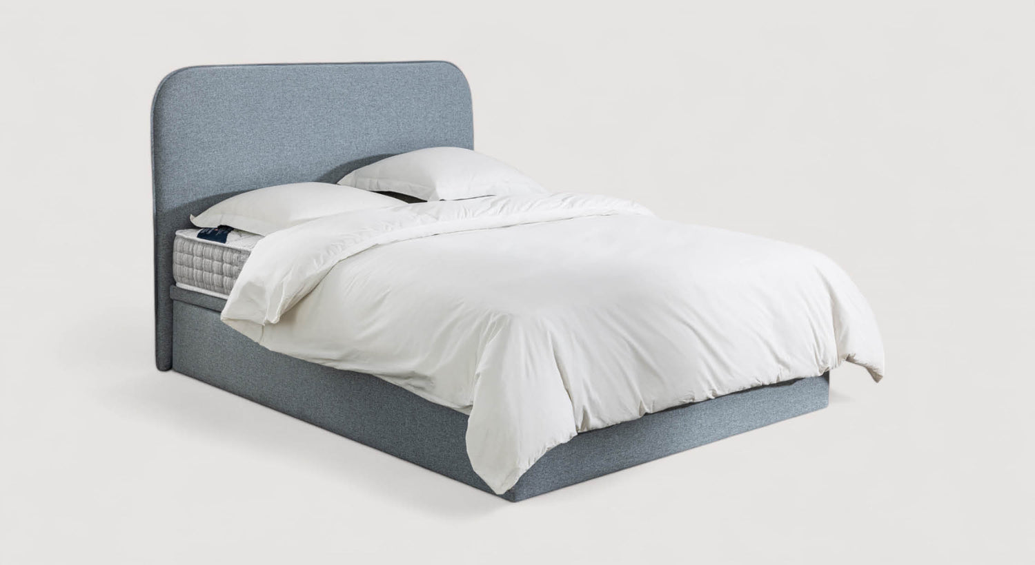 Lit coffre Monaco avec tête de lit arrondie en tissu gris, draps blancs