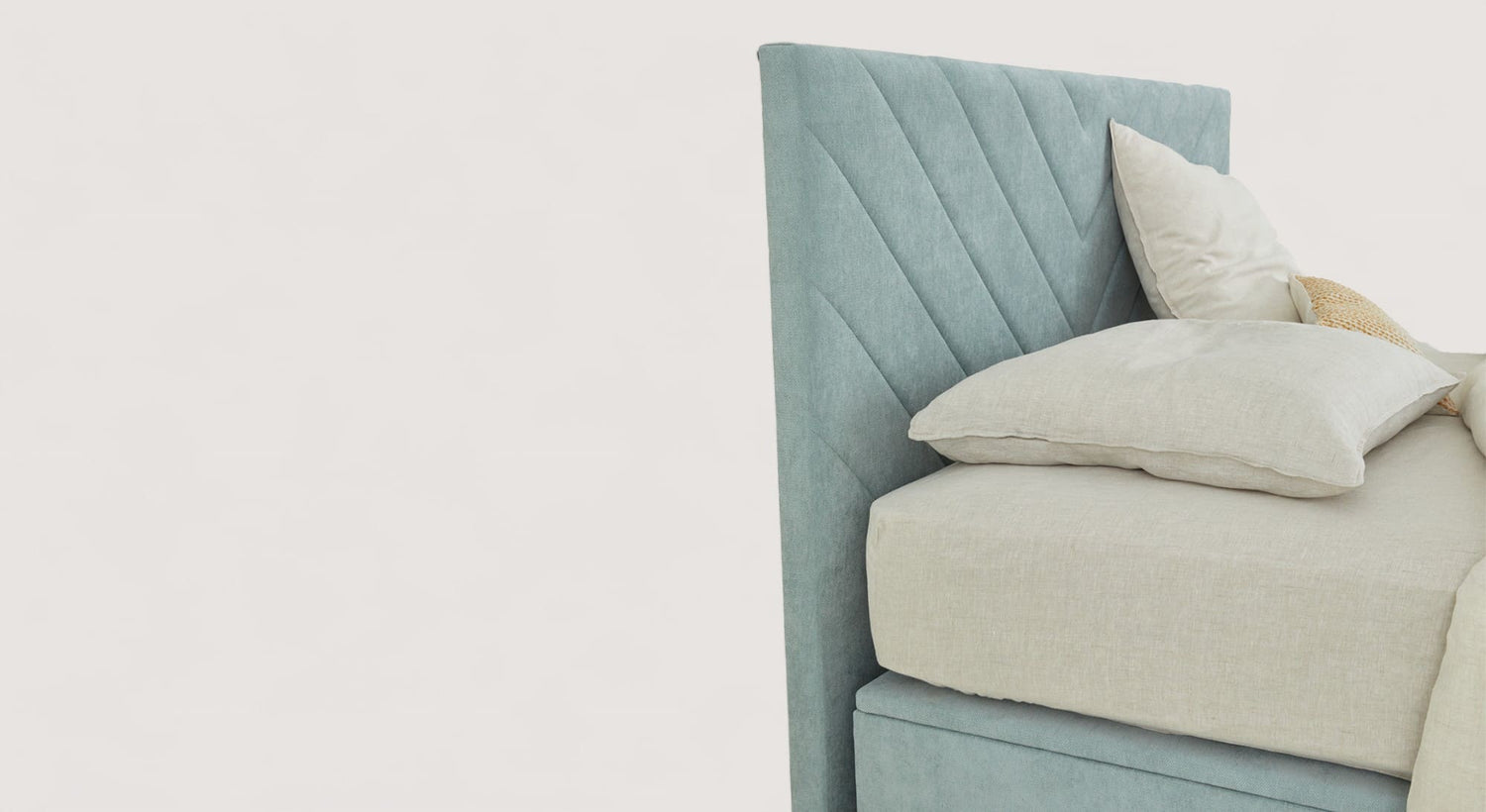 Tête de lit en tissu bleu avec motif chevron, accompagnée de coussins beiges