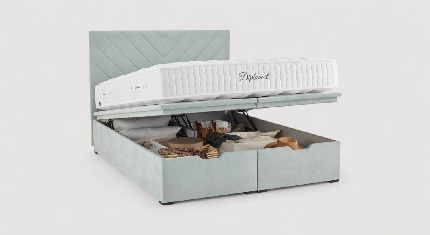 Lit coffre ouvert avec matelas "Diplomat", montrant un espace de rangement organisé avec divers articles