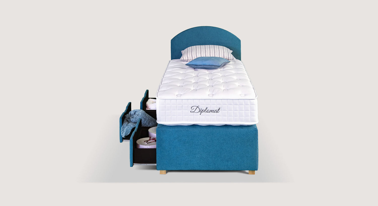 Lit bleu avec matelas "Diplomat", tiroirs ouverts contenant des objets