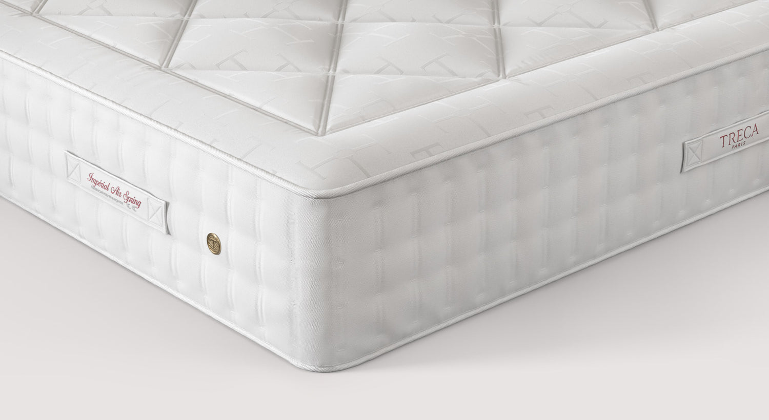 Matelas Treca Impérial Air Spring en gros plan, montrant le tissu matelassé et les étiquettes de marque