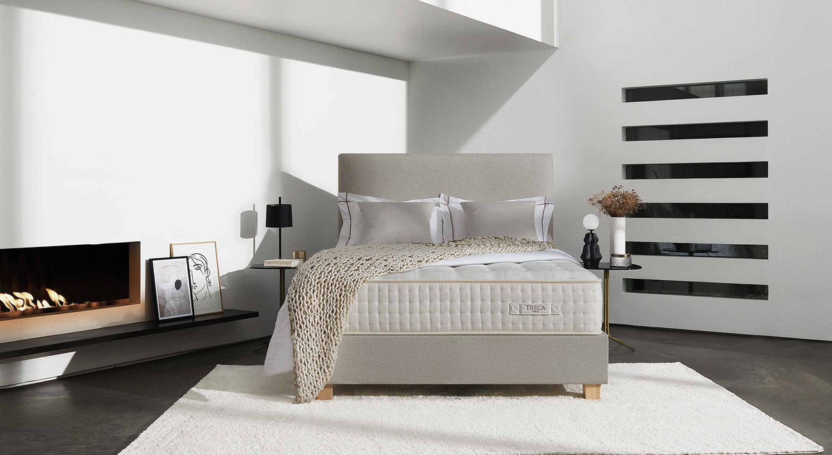 Chambre moderne avec matelas Treca Impérial Symphonie, décor minimaliste, cheminée allumée et œuvres d'art sur le mur