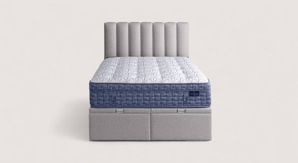 Lit avec tête de lit capitonnée grise et linge de lit orange, packshot pour Chandon