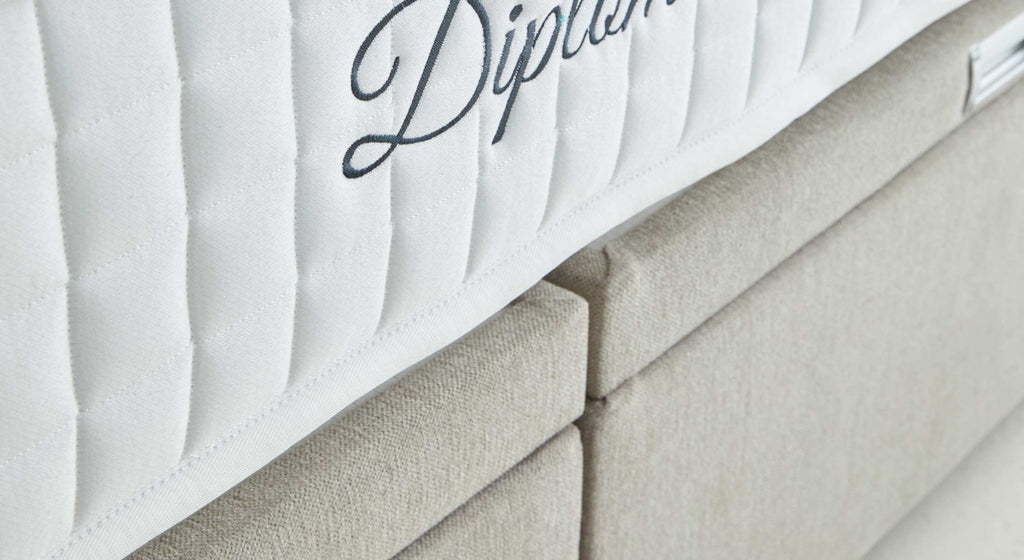 Poignée métallique sur un lit coffre en tissu beige, modèle Warren