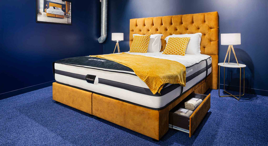 Tête de lit capitonnée en velours jaune moutarde avec coussin à motifs hexagonaux, ambiance élégante